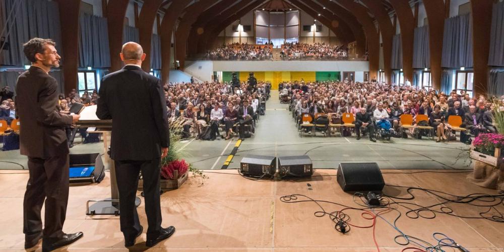 Adventist Church leader Ted N.C. Wilson, right, addressing the Adventist Theological Society youth convocation near Hanover, Germany, on Oct. 21, 2017, as Johannes Kolletzki interprets into German. (AYC: ATS Youth Congress / Facebook)