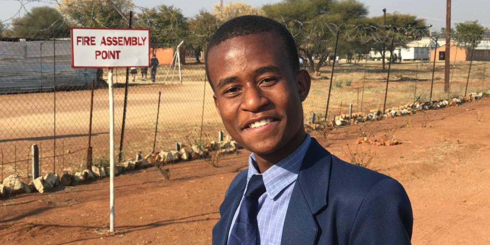 Unabatsho Sertse, 18, standing at the spot at Eastern Gate Academy that he saw in a dream before he visited the campus. (Andrew McChesney / Adventist Mission)