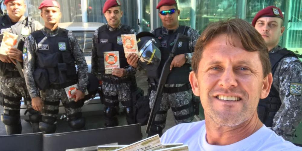 Church member Mateus Castanho posing with police officers in Brasilia, Brazil, after giving them 50 books. (SAD)