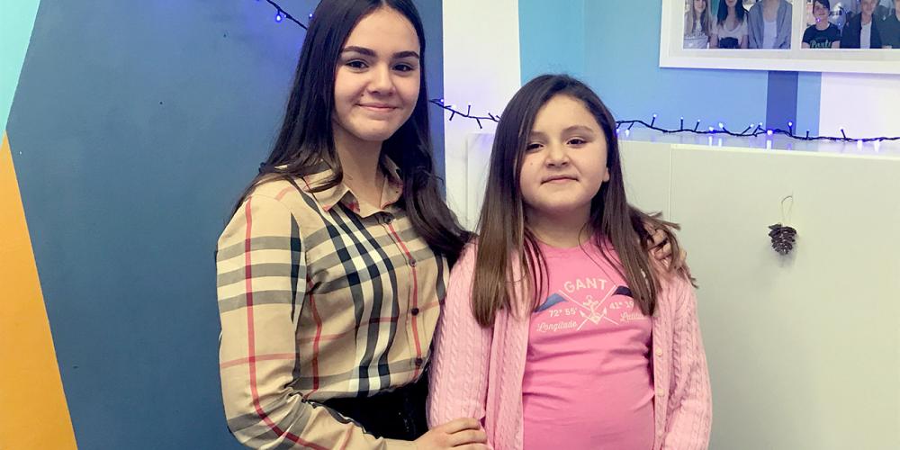 Yana Stoyka, 14, left, standing in her school classroom with her younger sister, Esther, in Prague, Czech Republic. (Andrew McChesney / Adventist Mission)