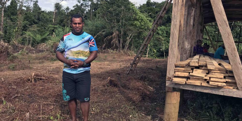 Kositela Tito, 33, standing near the open-air Seventh-day Adventist church just outside his father’s home village, Nakavika, in Fiji. Villagers, who belong to another Christian denomination, reluctantly allowed the church to be built after the death of Tito’s father but only outside the village. (Andrew McChesney / Adventist Mission)
