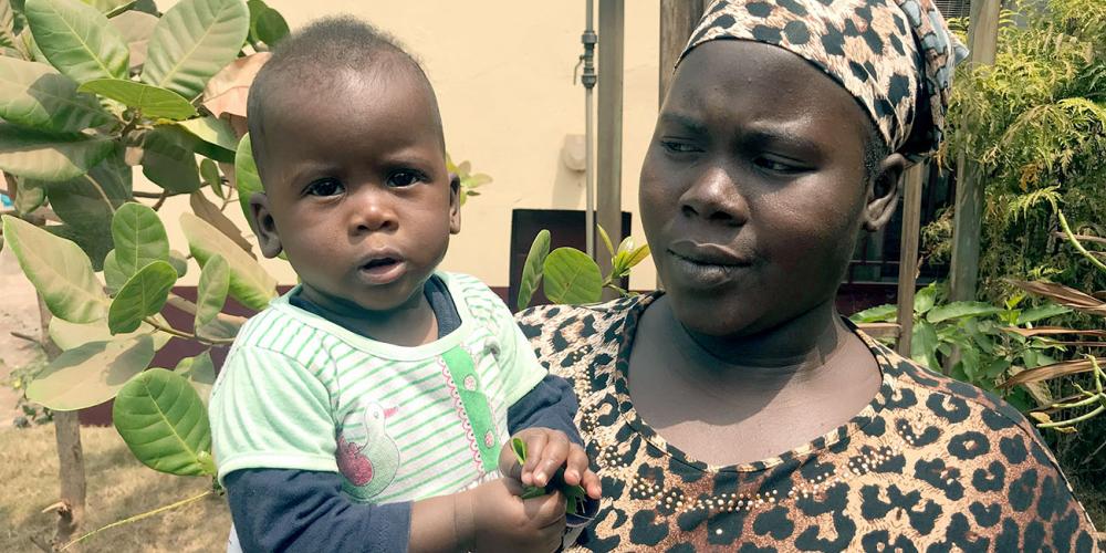 Fanta Camara, 33, holding her 8-month-old daughter, Oumou, in Conakry, Guinea. (Andrew McChesney / Adventist Mission)