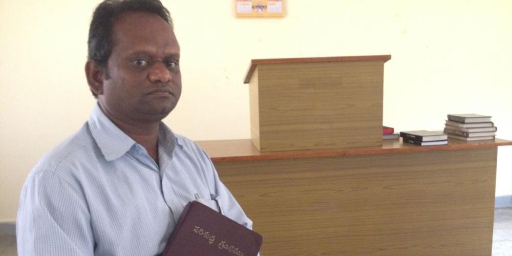 Samuel holding his Bible in a chapel at the headquarters of the Adventist Church's South Andhra Section in Ibrahimpatnam, India. (Andrew McChesney / Adventist Mission)