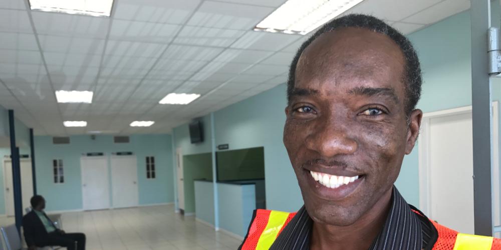 Andrew Carter standing at the entrance of the Good Samaritan Inn's new dental and medical departments in Kingston, Jamaica. (Andrew McChesney / Adventist Mission)