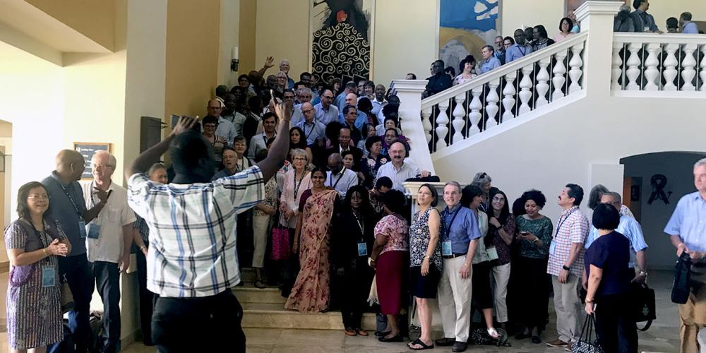 Attendees of the 12th Global Leadership Summit preparing to take a group photo on the stairs of a hotel in Montego Bay, Jamaica, on Feb. 6, 2019. (Andrew McChesney / Adventist Mission)