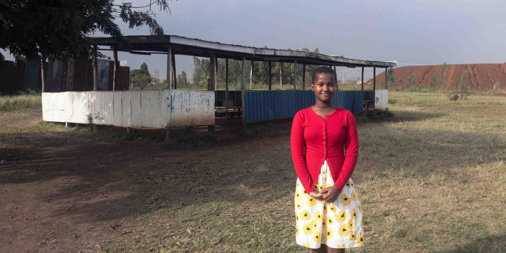 Abigalle Nyatich, 14, standing near the building where the Adventurers club meets on Sabbaths at Victory Seventh-day Adventist Church in Kisumu, Kenya. (Andrew McChesney / Adventist Mission)