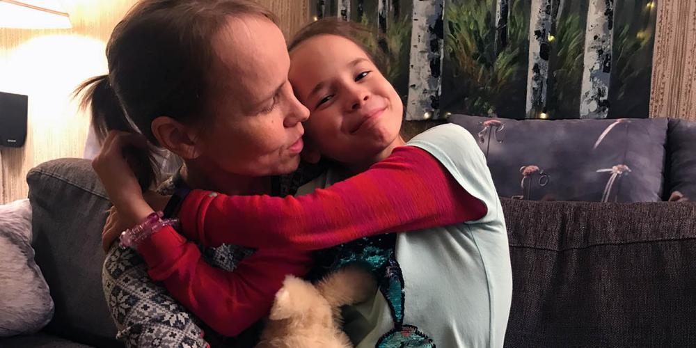 Rebeka Emma Keresi, 8, embracing her mother, Marion, in their home in Sortland, Norway. (Andrew McChesney / Adventist Mission)