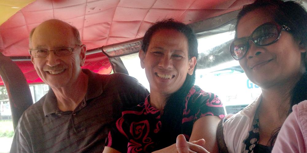 Steven Dragoo with his wife, Dorcas, center, traveling by taxi in the Philippines. (For Adventist Mission)