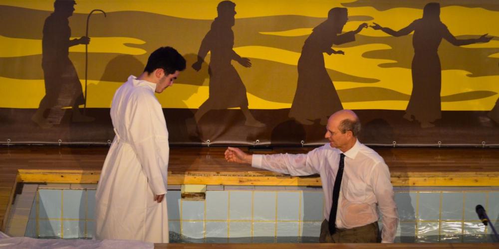 Adventist Church president Ted N.C. Wilson inviting a man into the water for baptism at Floresti Seventh-day Adventist Church in Floresti, Romania, on Feb. 25, 2017. (Romanian Union)