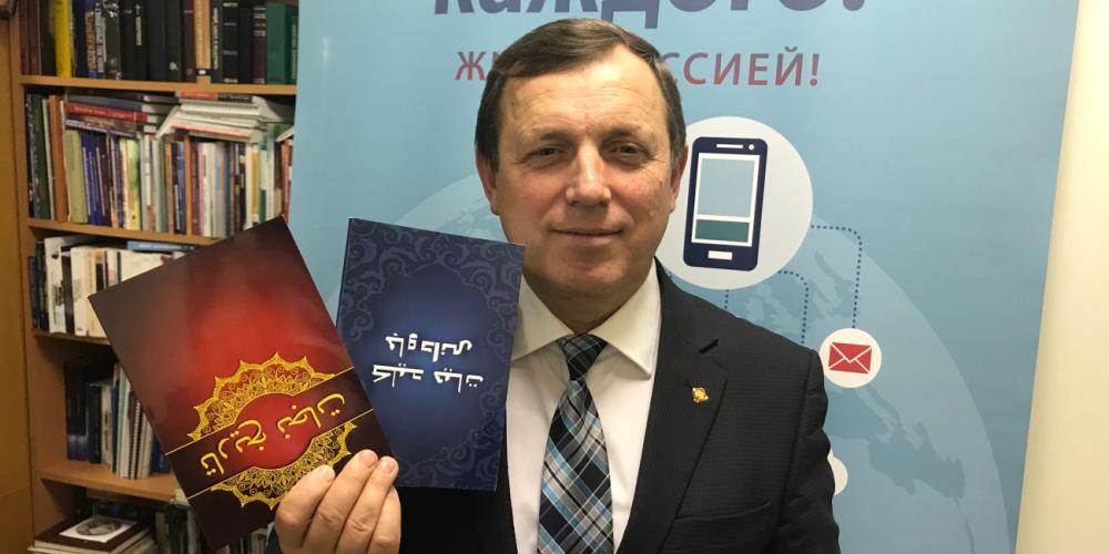 Pavel Liberanskiy, publishing ministries director for the Adventist Church’s Euro-Asia Division, showing “Steps to Christ” and “The Story of Redemption” in Farsi. (Andrew McChesney / Adventist Mission)