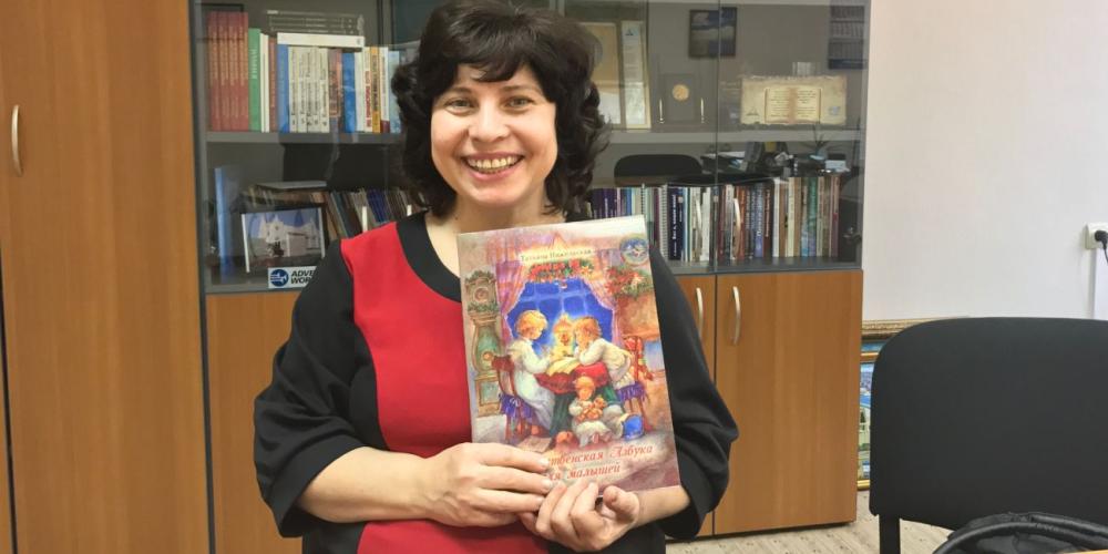 Tatiana Nizhelskaya holding a book of religious poems for children, one of 11 books that she has written. (Andrew McChesney / Adventist Mission)