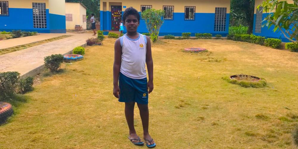 Dadyslau Sacramento standing near classrooms at the Adventist school in São Tomé. (Andrew McChesney / Adventist Mission)