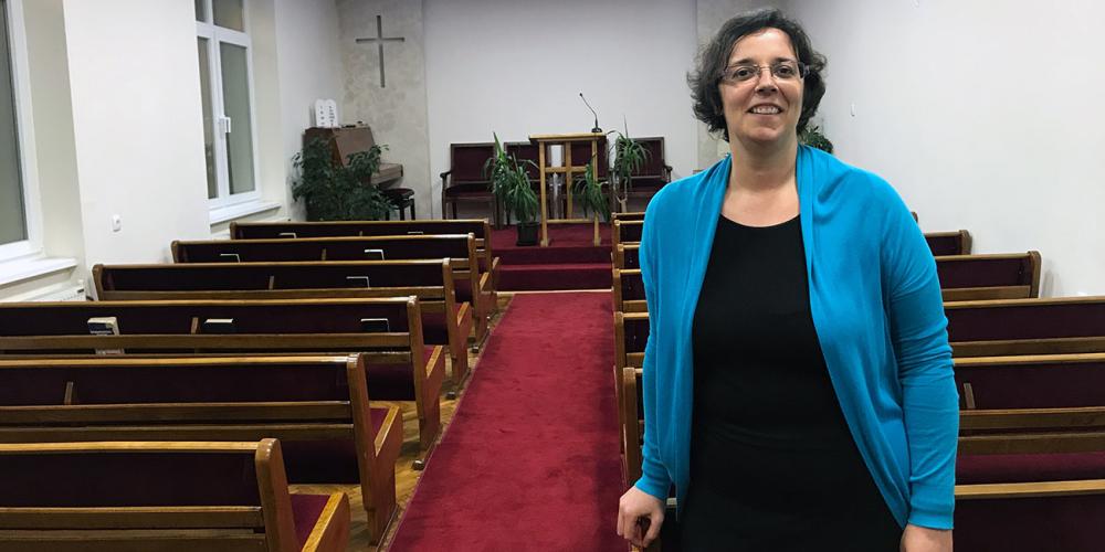 Jelena Dubljević, 40, standing in the sanctuary that New Belgrade Seventh-day Adventist Church shares with another congregation in Zemun, Serbia. (Andrew McChesney / Adventist Mission)
