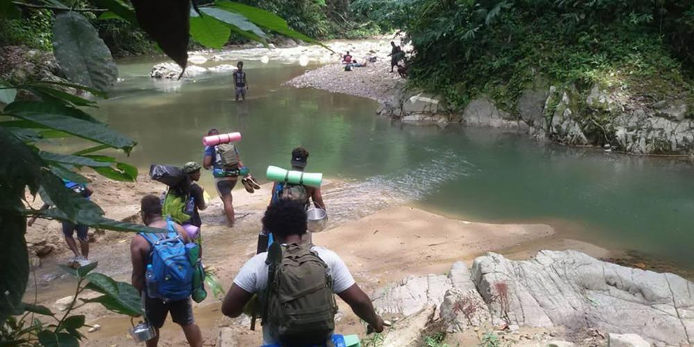 Young Solomon Islanders, ages 16 to 21, crossing a jungle river as they hike to a remote village for Jungle Ministry, an outreach program. (All Photos: South Pacific Adventist Record)