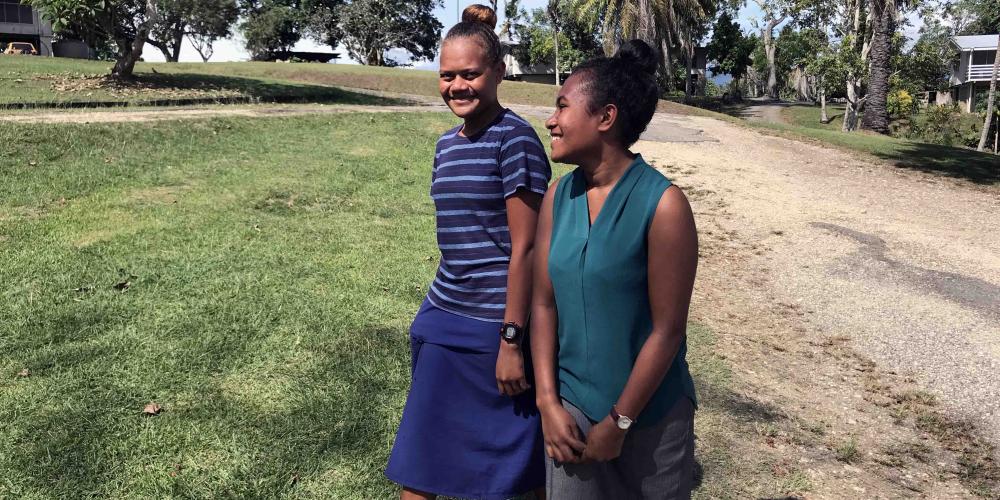 Kinnie Aitorea, 18, right, walking with Mitlyn Todong, 15, on the compound of the Adventist Church’s headquarters in Honiara, Solomon Islands. (Andrew McChesney / Adventist Mission)