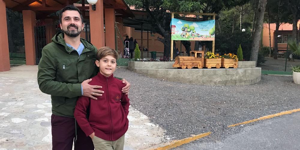 David Lucas Dolete Druga, 10, standing with his father, Laurentiu Stefan Druga, at the gate to the elementary school at Sagunto Adventist College in Sagunto, Spain. (Andrew McChesney / Adventist Mission)