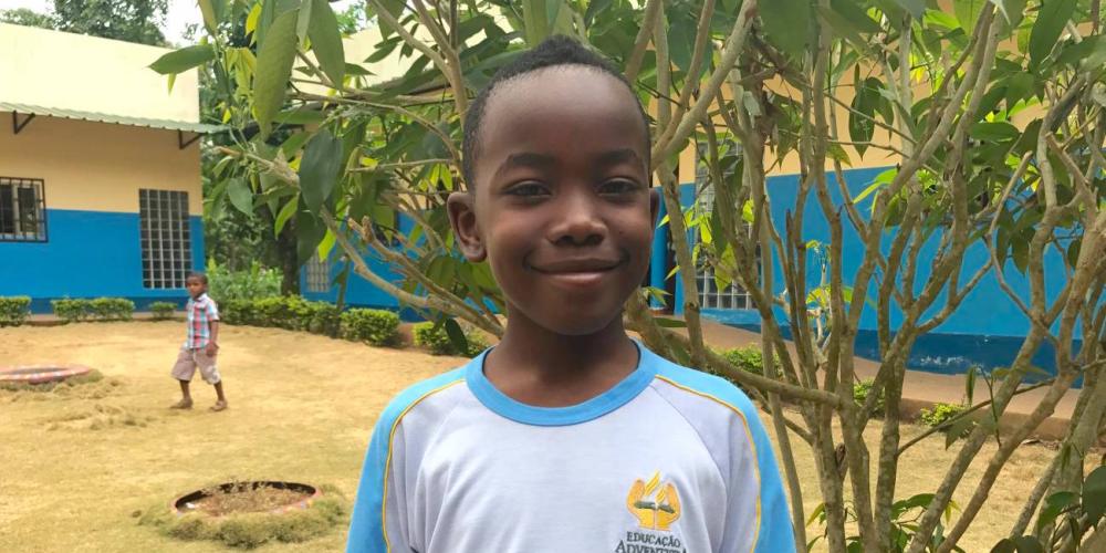 Anselmo Barros, pictured, fought with his older sister until he heard the biblical story of Joseph at the Adventist school, background, in São Tomé and Príncipe. (Andrew McChesney / Adventist Mission)