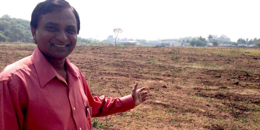Vara Prasad Jacob, president of the South Andhra Section, showing the field where the Pioneer Memorial Discipleship Training Center will be built. The rest of the church compound is visible in the background. (Photos: Andrew McChesney / Adventist Mission)