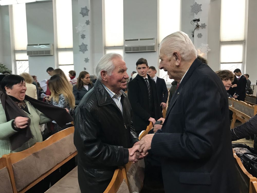 Nikolai Zhukalyuk, right, speaking with a church member at Seventh-day Adventist Church No. 3 in Kiev, Ukraine, on Feb. 4, 2017. (Andrew McChesney / Adventist Mission)