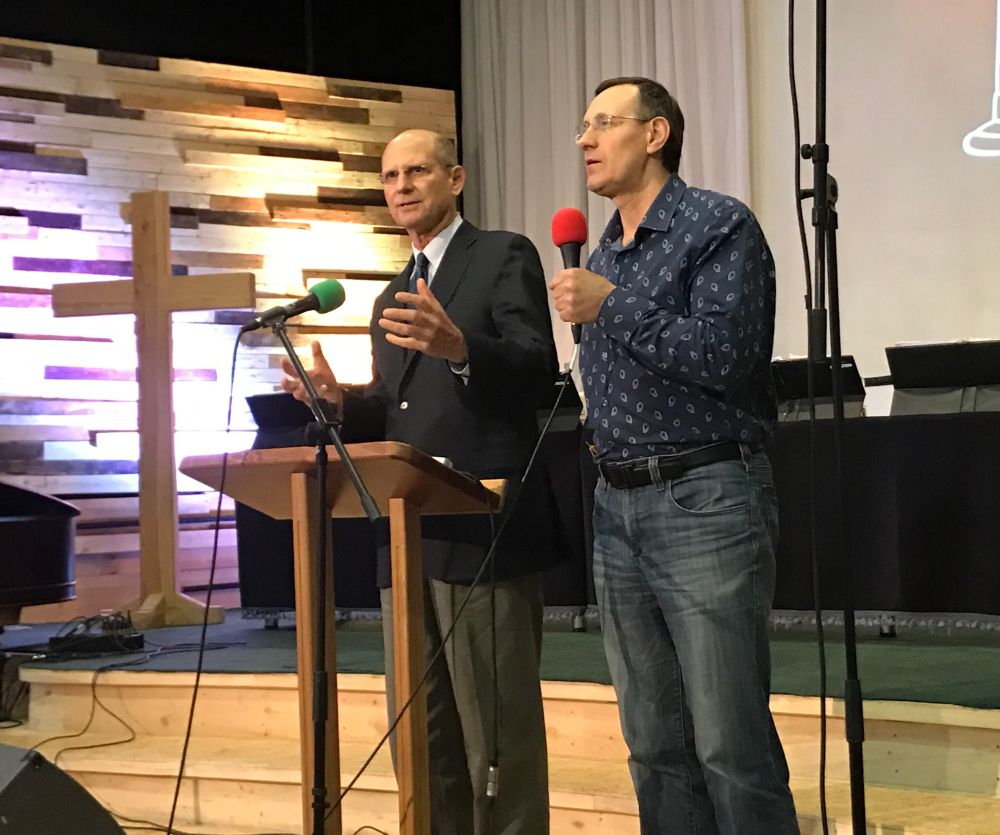 Adventist Church president Ted Wilson, left, speaking at an orientation meeting on the Bucha campus as Euro-Asia Division president Michael Kaminskiy interprets into Russian. (Andrew McChesney / Adventist Mission)