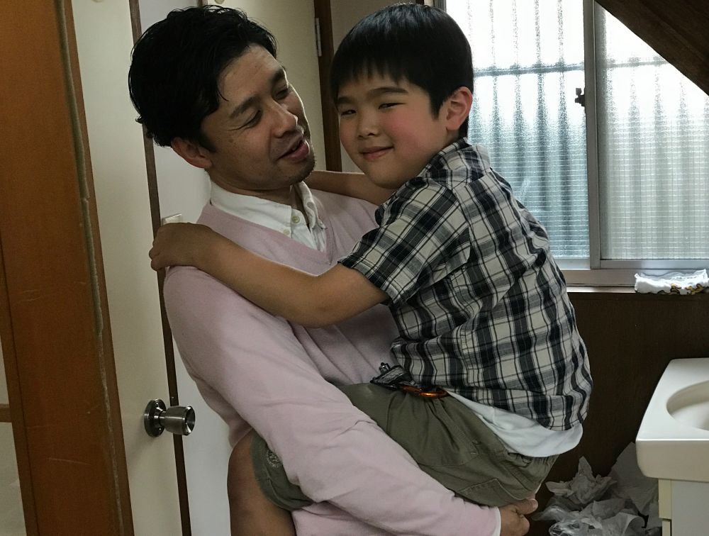 Yasuki Aoki speaking with one of his sons outside the sanctuary of Setagaya Church in Tokyo, Japan. (Andrew McChesney / Adventist Mission)
