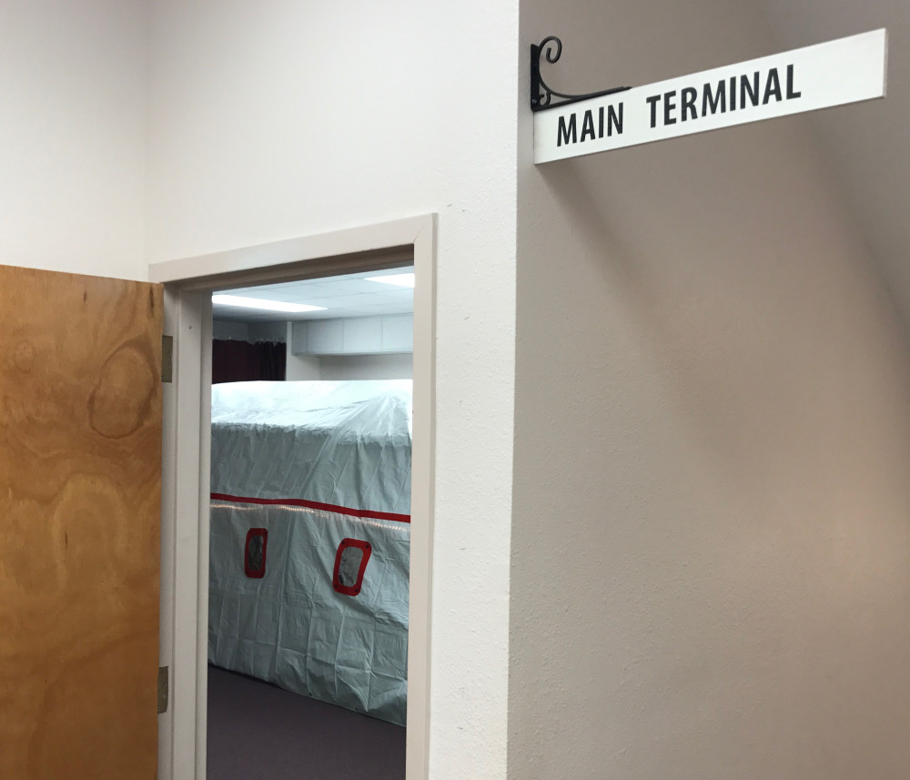 A sign reading "Main Terminal" is fastened above the airline check-in desk.