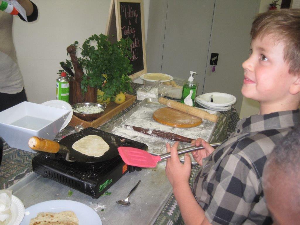 A boy learning to make chapatis, an unleavened flatbread that is a popular staple in India.