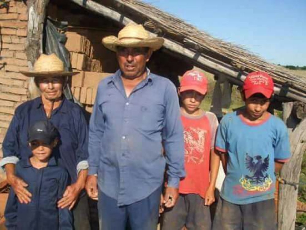 Antonio Pedrozo, right, posing with his adopted parents and other relatives outside the house with bricks made by him and his brother. (Family photo)