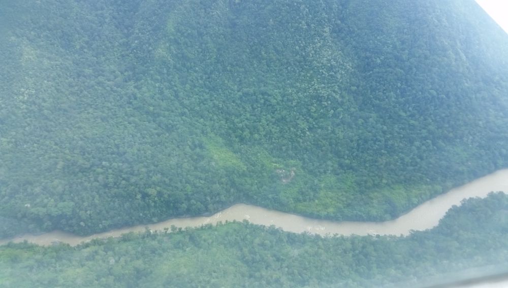 A bird's-eye view of Waghi River through clouds. The Adventists crossed at one of the bends.