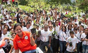 Hundreds of Seventh-day Adventists hold out small trees before planting some 270 trees in during the church’s “Planting Hope” program to beautify Venezuela’s parks.