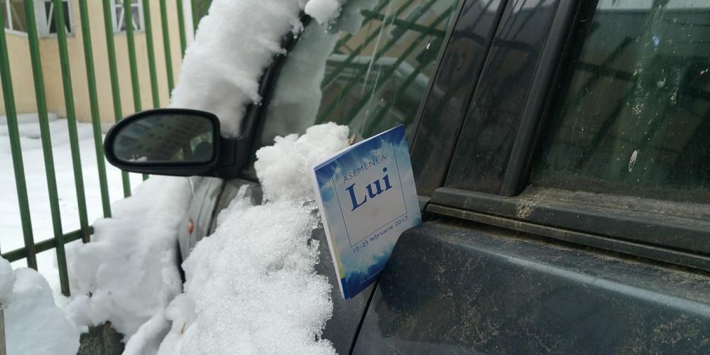 A GLOW tract stuck in a car door on a snowy street in Romania's capital, Bucharest, this week. (GLOW / Facebook)