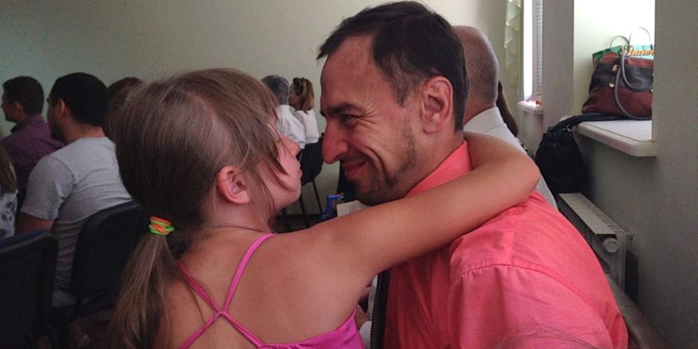 Valentin Zaitsev speaking with his daughter during a break between Sabbath School and the main worship service at the church where he serves as deacon in Mykolaiv, Ukraine. (Photos: Andrew McChesney / Adventist Mission)