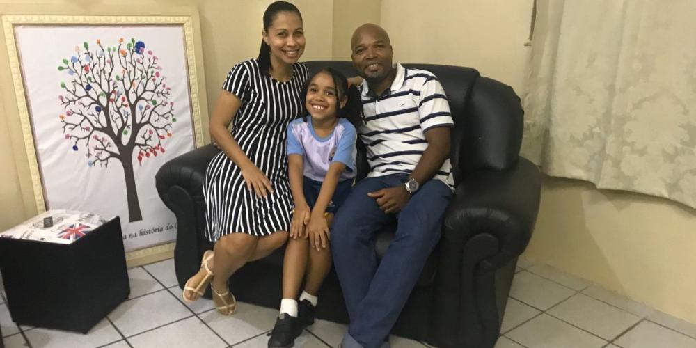 Carine Cardoso de Oliveira, 7, with her parents at her Seventh-day Adventist elementary school in Salvador, Brazil. (Andrew McChesney / Adventist Mission)