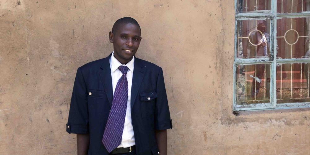 Francis Ndacha, 32, standing near his temporary home in Kisumu, Kenya. He and his family travel around the country as he preaches the gospel. (Andrew McChesney / Adventist Mission)